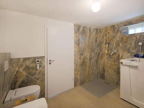 Bodengleiche Dusche im Badezimmer mit Badewanne und WC - 