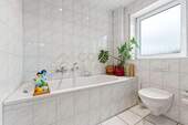Lichtdurchflutetes Badezimmer mit Dusche und Badewanne - 