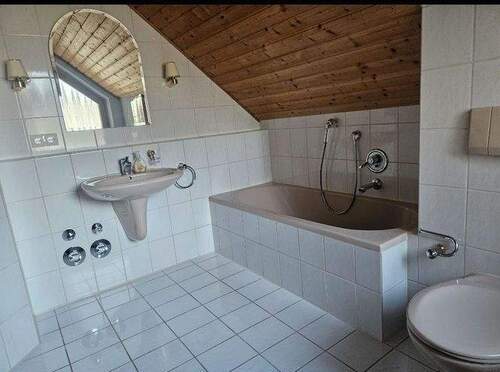 Badezimmer mit Wanne, Dusche und Fenster - 