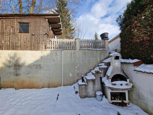 Gartenbereich mit Holzhaus und Grill - 