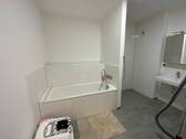 Badezimmer mit grauen Bodenfliesen und weißen Wandfliesen, Badewanne.JPG - 