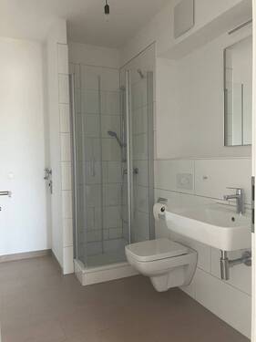 innenliegendes Duschbad, wandhängenden WC und Handtuchheizkörper,. Der Boden ist dunkel gefließt. - 