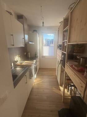 Einbauküche mit Zugang zur Loggia, helle Fronten, graue Rückwand - 