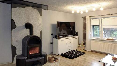 Wohnzimmer mit Kaminofen - Einfamilienhaus mit 140,00 m² in Oberweid zum Kaufen