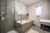 helles Badezimmer mit Wanne und Dusche - 