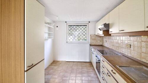 Küche mit angrenzender Garage und Zugang zum Keller - 