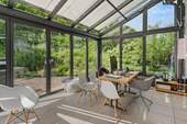Harmonisch in die Umgebung integrierter Wintergarten mit Terrassenzugang, Fußbodenheizung und Beschattung - 