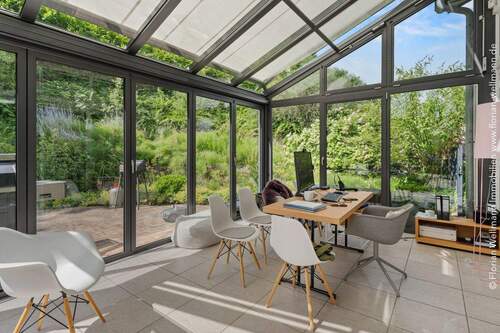 Harmonisch in die Umgebung integrierter Wintergarten mit Terrassenzugang, Fußbodenheizung und Beschattung - 