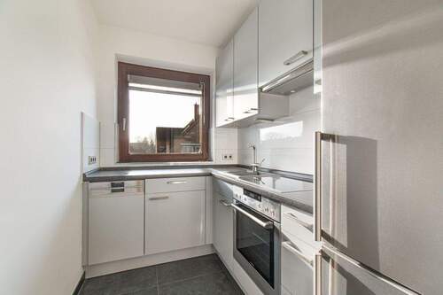 Einbauküche mit hochwertigen Geräten und praktischer Wandbefliesung - 