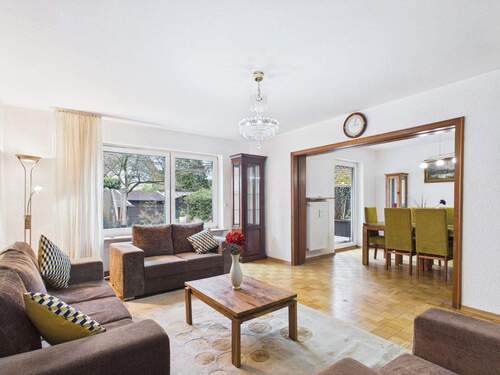 Heller Wohnbereich mit großer Fensterfront - Möblierte 3-Zimmer-Gartenwohnung mit Kamin und Einbauküche