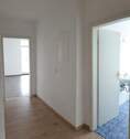 Flur mit Blick ins Wohnzimmer und ins Bad - 