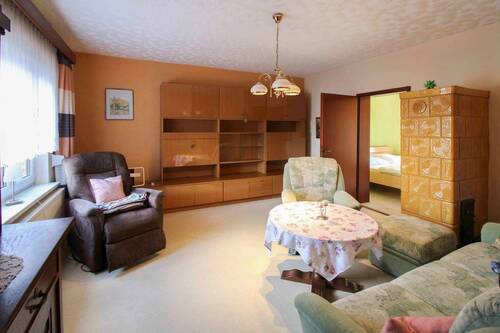 Wohnzimmer mit Kachelofen - Doppelhaushälfte mit 90,10 m&sup2; in Groß Nemerow zum Kaufen