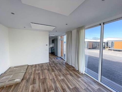 Wohnbereich mit Haustür und Küche im Hintergrund - 