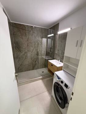 Bad mit großer Dusche und Waschmaschine - 