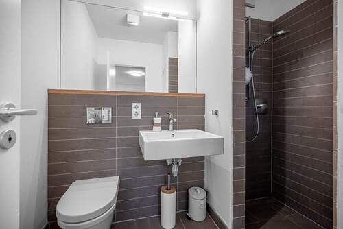 Modernes Duschbad mit klarer Linienführung und eleganten Fliesen - 