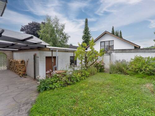 Überdachter Verbindungsbereich zwischen Haus und Garagen – ideal als Holzlager - 