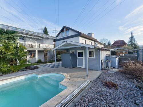 Moderner Gartenbereich mit Pool und überdachter Terrasse - 