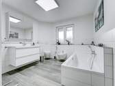 Neubau – Großes Badezimmer mit Badewanne, Bidet und Doppelwaschtisch - 