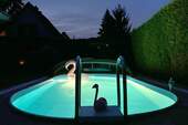 Swimmingpool mit fahrbarem Dach bei Nacht - 