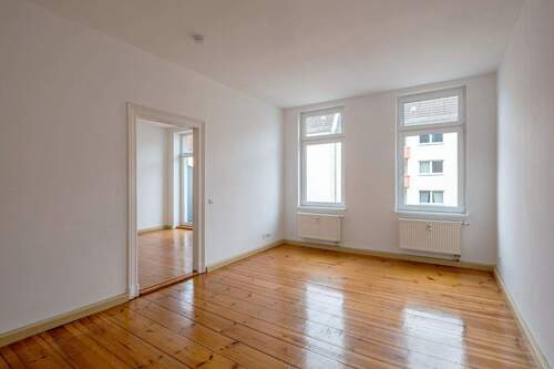 Wohnzimmer mit Blick zum Schlafzimmer und Balkon - 2 Zimmer Etagenwohnung in Berlin-Friedrichshain