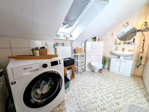 Das Badezimmer mit Dusch-Badewanne und Waschmaschi - 