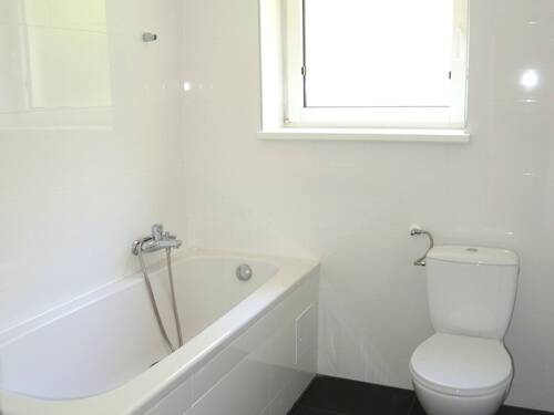 Badezimmer mit Wanne und Fenster - 