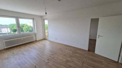 Renoviertes Wohnzimmer mit Laminatfußboden und Südbalkon. - Mehrfamilienhaus, Wohnhaus mit 2.508,70 m² in Bremen zum Kaufen