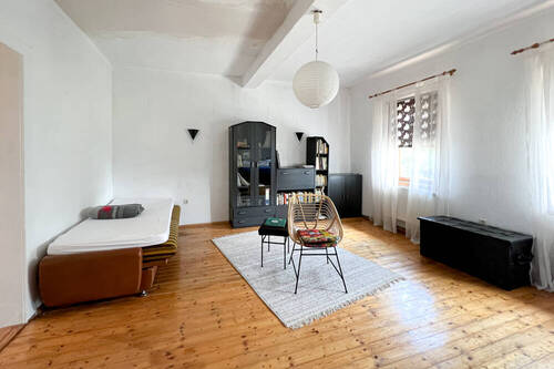 Großes Zimmer mit abgeschliffenem Holzboden - 