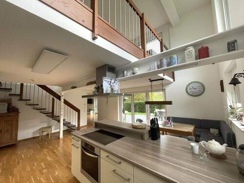 Blick aus der Küche auf den Essbereich und die Terrasse sowie auf die Galerie im Erdgeschoss - 