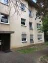 Gebäude Vorderseite des mehrstöckigen Wohnhauses umgeben von Grünanlagen mit Bäumen - Gemütliche, kleine 2-Zimmerwohnung sucht neue Mieter!