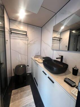 Luxuriöses Designerbad mit edler Marmoroptik und schwarzen Akzenten - 