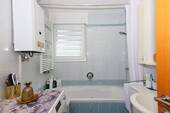 Gepflegtes Badezimmer mit Badewanne und Fenster - 