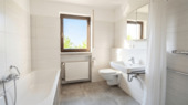 Modernisiertes Badezimmer mit Dusche und Badewanne - 