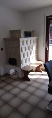 Esszimmer mit Kachelofen und Zugang zum Balkon - 