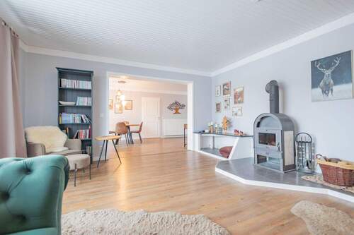 Wohnzimmer mit Ofen - 8 Zimmer Mehrfamilienhaus, Wohnhaus zum Kaufen in Lohe-Föhrden