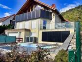 Ansicht 2 Front mit Pool und Balkonkraftwerk - Exklusives Einfamilienhaus in moderner Chalet-Architektur mit Waldblick