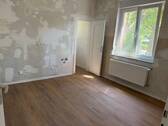 Küche mit tapetenfreien Wänden, braunem Vinyl-Designboden in Holzoptik und Zugang zum Abstellraum - 