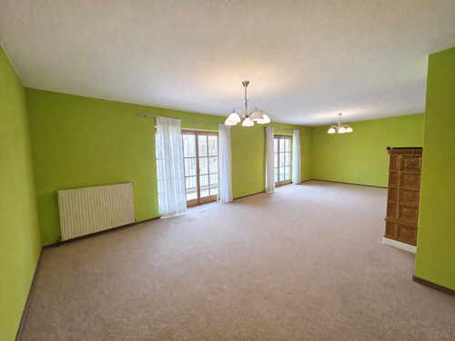 Großes Wohnzimmer mit Kachelofen und Zugang zur Terrasse - 4 Zimmer Doppelhaushälfte in Landsberg am Lech