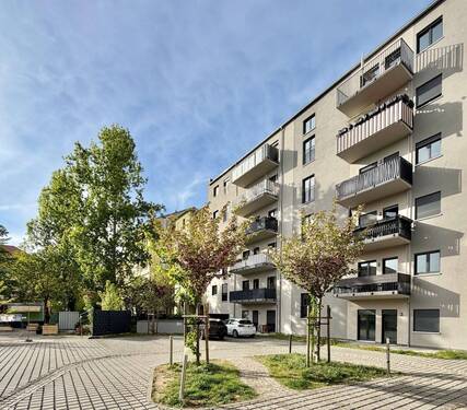 Haus Hinteransicht - Neuwertige 3,5-Zimmer-Wohnung mit 2 Balkonen, Aufzug und TG-Stellplatz in zentraler Lage
