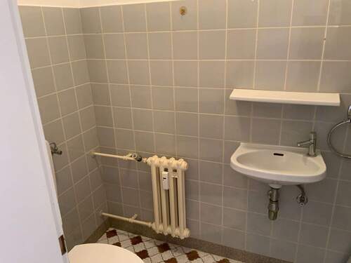 Gäste WC mit kariert schwarz/weißen Bodenfliesen und gräulichen Wandfliesen/ - 