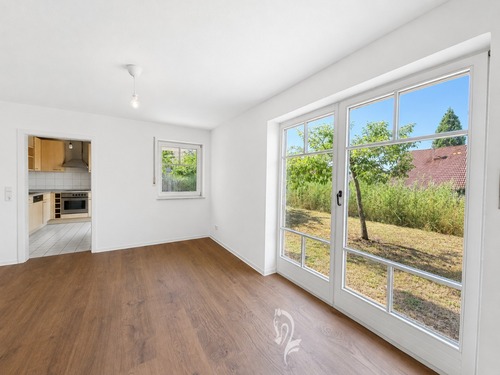 Wohnzimmer und Ausblick in den Garten - 2 Zimmer Terrassenwohnung zum Kaufen in Eibelstadt