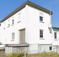 Lagerhalle mit Rolltor und Laderampe auf Gewerbegelände – Dillenburg