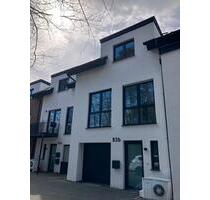 Zentral mieten in Schloß Holte-Stukenbrock: Familienfreundliches Neubau-Reihenhaus mit 166 m² Wfl. zzgl. 26 m² Spitzboden | Kleingarten, Terrasse + Dachterrasse | Keller, Garage, optionaler STP
