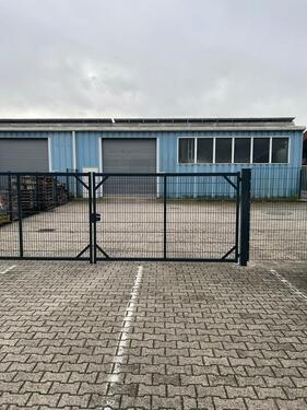 Foto - Moderne Industriehalle mit eingezäunter Außenfläche