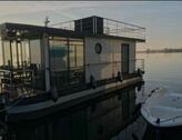 Foto - Festliegendes Hausboot mit großer Dachterrasse und Ruderboot