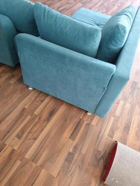 Foto - Es handelt sich um ein blaues Ecksofa, das möglicherweise über