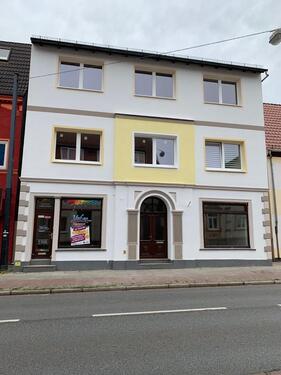 Foto - Geschäfts und Wohnhaus mit Garten und Baufläche.