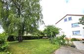 Hausansicht mit Gemeinschaftsgarten - 