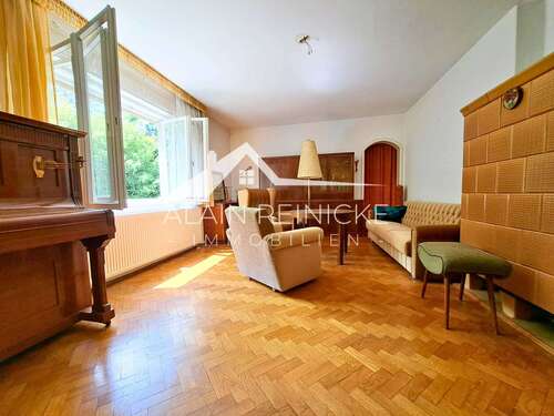 Wohnzimmer mit großen Fenstern und Kamin - 