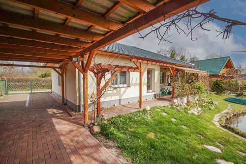 Hausansicht mit Einfahrt - Wasserlage mit Seltenheitswert – stilvoller Bungalow mit eigenem Wasserzugang & Anlegestelle